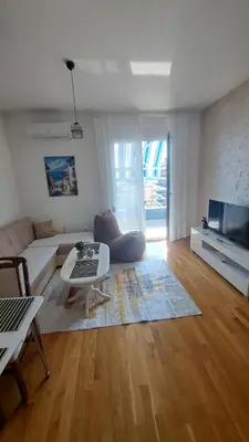 a living room with a couch and a table at Blue wave apartman in Becici
