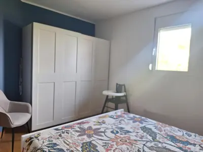 a bedroom with a bed and a door and a window at Apartment Alma in Kravlja