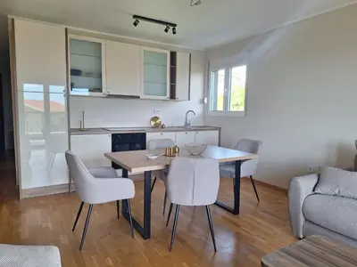 a kitchen and dining room with a table and chairs at Apartment Alma in Kravlja