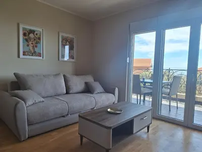 a living room with a couch and a table at Apartment Alma in Kravlja