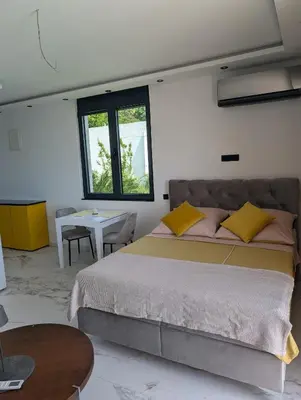 a bedroom with a large bed and a table at Apartment Anja in Dobra Voda