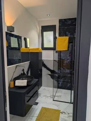 a bathroom with a sink and a shower with yellow towels at Apartment Anja in Dobra Voda