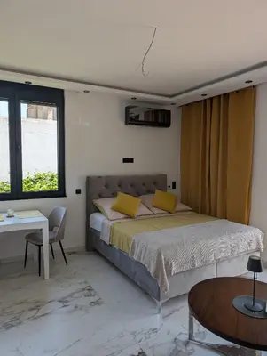 a bedroom with a large bed and a table at Apartment Anja in Dobra Voda