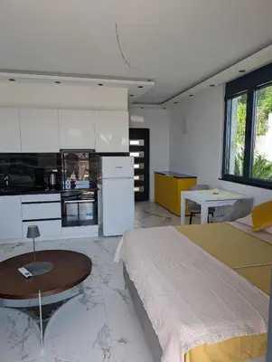 a kitchen and a bedroom with a bed and a table at Apartment Anja in Dobra Voda