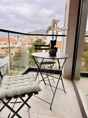 a table and chair on a balcony with a view at Monte Rama Suite Rafailovici in Budva