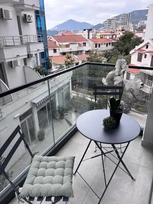 a table and chair on a balcony with a view at Monte Rama Suite Rafailovici in Budva