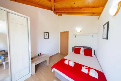 a bedroom with a large bed with red pillows at Villa Rustique in Budva