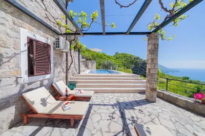 a patio with two lounge chairs and a pool at Villa Rustique in Budva