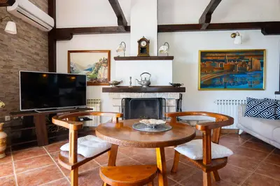 a living room with a table and a fireplace at Villa Rustique in Budva