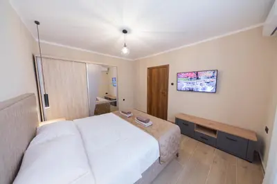 a bedroom with a large white bed and a tv at Villa Jana Lapčići in Lapčići