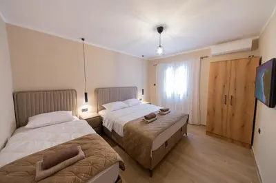 a bedroom with two beds and a television in it at Villa Jana Lapčići in Lapčići