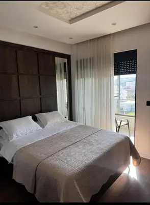 a bedroom with a large bed with a large window at Moon Apartment in Ulcinj