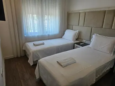 a hotel room with two beds and a window at Moon Apartment in Ulcinj
