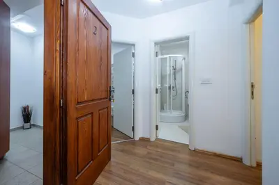 a hallway with a wooden door and a bathroom at Vila Lancana in Kotor