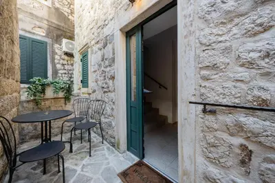 a patio with a table and chairs and a door at Vila Lancana in Kotor