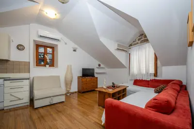 a living room with a red couch and a table at Vila Lancana in Kotor