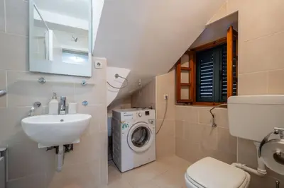 a bathroom with a washing machine and a sink at Vila Lancana in Kotor