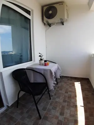 a table and chair in a room with a window at Apartments Snezana in Bar