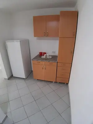 a kitchen with wooden cabinets and a refrigerator at Apartments Snezana in Bar