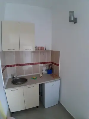 a small kitchen with a sink and white cabinets at Apartments Snezana in Bar