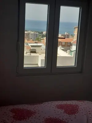 a bedroom window with a view of the ocean at Apartments Snezana in Bar