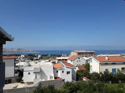 a view of a city with houses and the ocean at Apartments Snezana in Bar