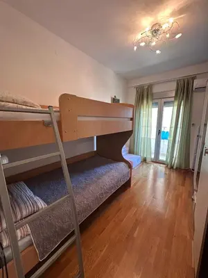 a bedroom with two bunk beds and a chandelier at Apartments EVG in Rafailovici
