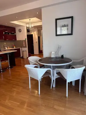 a dining room with a table and chairs and a kitchen at Apartments EVG in Rafailovici