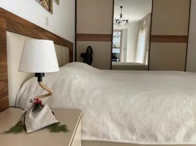 a bedroom with a bed and a lamp on a table at DimaX Apartments in Budva