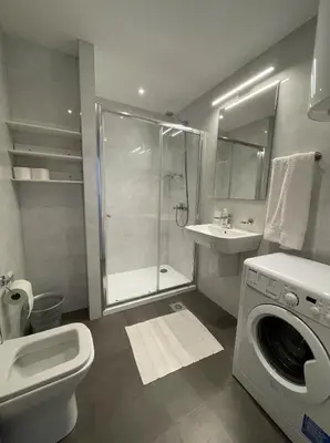 a bathroom with a shower sink and a washing machine at DimaX Apartments in Budva