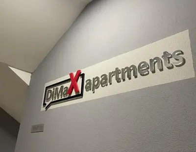 a sign on a wall with a red bow on it at DimaX Apartments in Budva