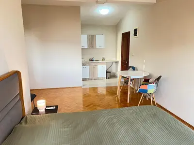 a bedroom with a bed and a table and a kitchen at Eco Villa Buljarica in Buljarica