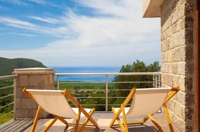 two chairs on a balcony with a view of the ocean at Eco Villa Buljarica in Buljarica
