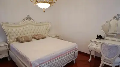 a bedroom with a bed and two tables and a chandelier at Villa Lux Radovici in Radovići