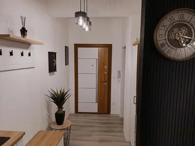 a hallway with a door and a clock on the wall at Cozy Home in Ulcinj