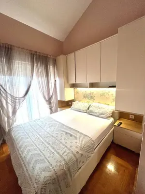 a bedroom with a large bed and a window at sinbia apartment in Budva