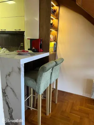 a kitchen with a counter with a bar stool at sinbia apartment in Budva