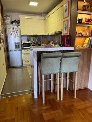 a kitchen with a counter and two bar chairs at sinbia apartment in Budva