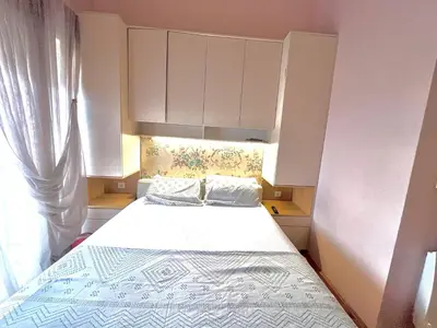 a small bedroom with a bed and a window at sinbia apartment in Budva