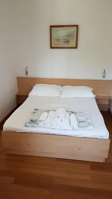 a bed with three rolls of towels on it at Apartmani Famelja Jovanovic in Sveti Stefan