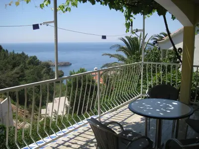 a balcony with a table and chairs and the ocean at Apartmani Famelja Jovanovic in Sveti Stefan