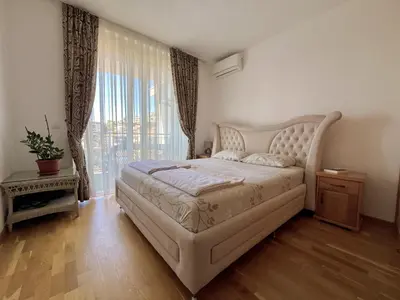 a bedroom with a large bed and a large window at Plaza Apartment in Budva