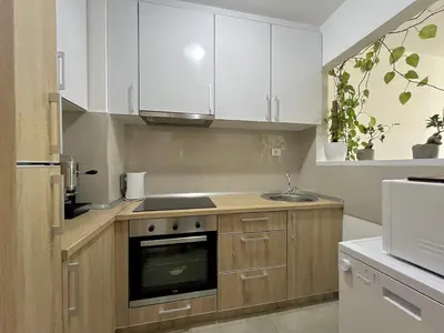 a kitchen with white cabinets and a sink at Plaza Apartment in Budva