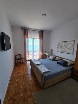 a bedroom with a large bed and a television at Family Sea View Ulcinj in Ulcinj