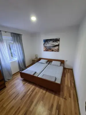 a bedroom with a bed and a wooden floor at Family Sea View Ulcinj in Ulcinj