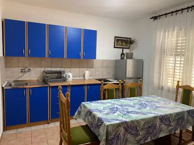 a kitchen with blue cabinets and a table and a sink at Family Sea View Ulcinj in Ulcinj