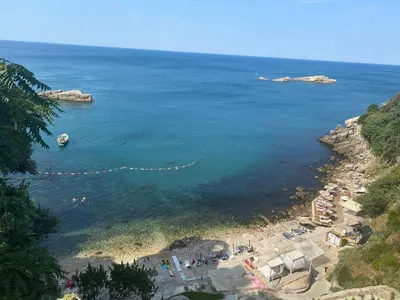 a beach with a group of people in the water at Family Sea View Ulcinj in Ulcinj
