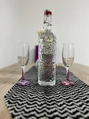 a bottle of wine and two wine glasses on a table at Lutovac Apartmani in Kotor