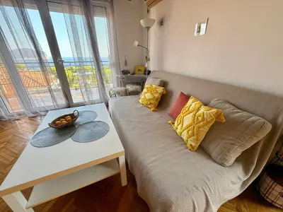 a couch with two pillows and a table in a room at La Marea in Petrovac na Moru