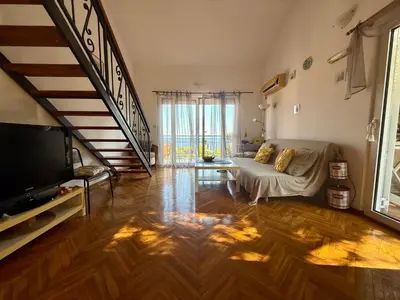 a living room with a couch and a staircase at La Marea in Petrovac na Moru